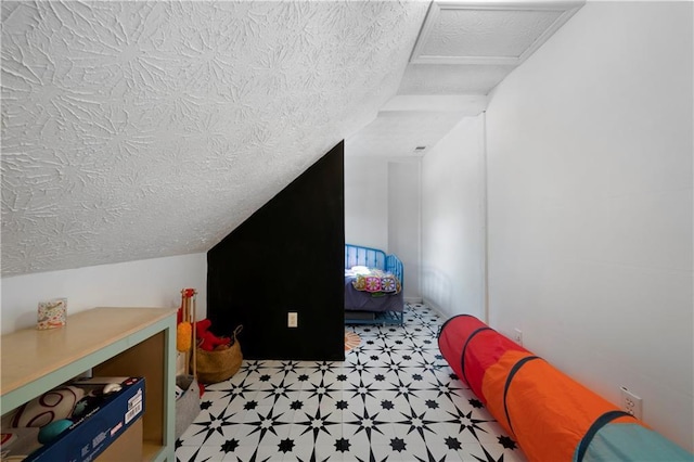 bedroom with a textured ceiling and vaulted ceiling