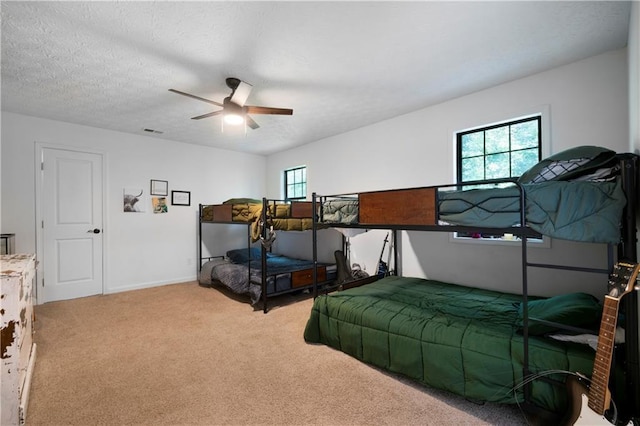 bedroom featuring a textured ceiling, ceiling fan, and carpet flooring