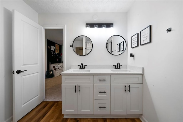 bathroom featuring hardwood / wood-style floors, vanity, and a textured ceiling