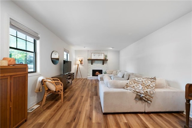 living room featuring hardwood / wood-style floors and a stone fireplace