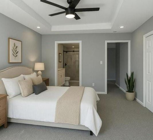 carpeted bedroom with a raised ceiling, baseboards, recessed lighting, ensuite bathroom, and ceiling fan