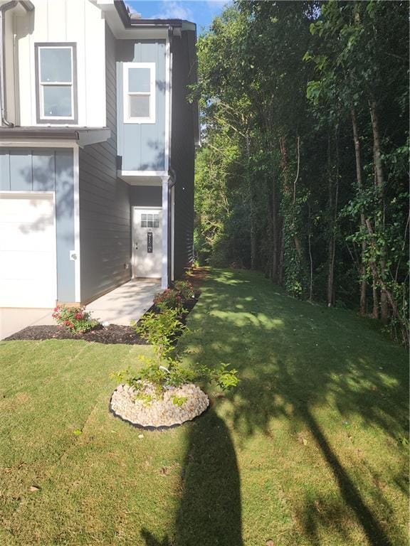 view of green lawn featuring a garage