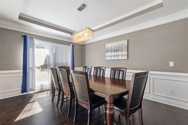 dining room featuring dark hardwood / wood-style flooring, ornamental molding, a tray ceiling, and a chandelier