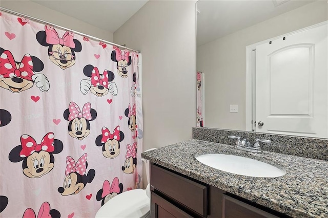 bathroom featuring vanity, curtained shower, and toilet