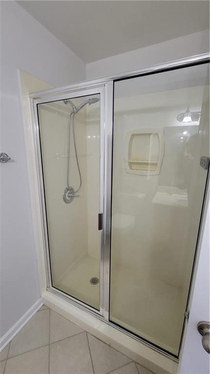 bathroom featuring tile patterned flooring and a shower stall