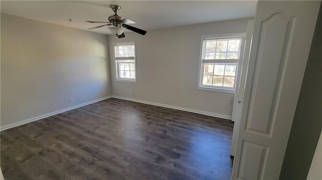 unfurnished room with ceiling fan, dark wood finished floors, and baseboards