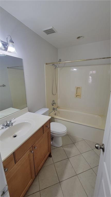 full bathroom with visible vents, toilet, shower / tub combination, tile patterned flooring, and vanity