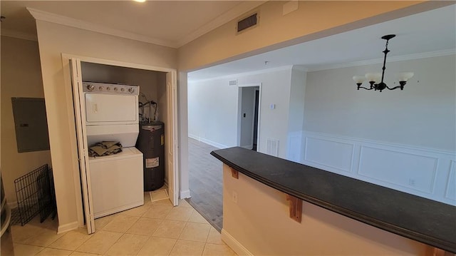 hall featuring ornamental molding, visible vents, stacked washing maching and dryer, and electric water heater