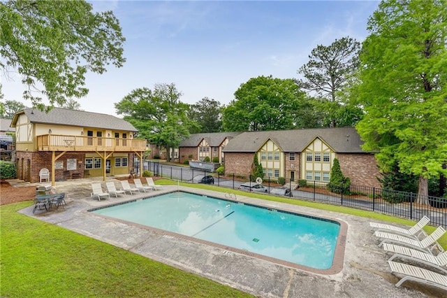 pool featuring fence, a patio, and a yard