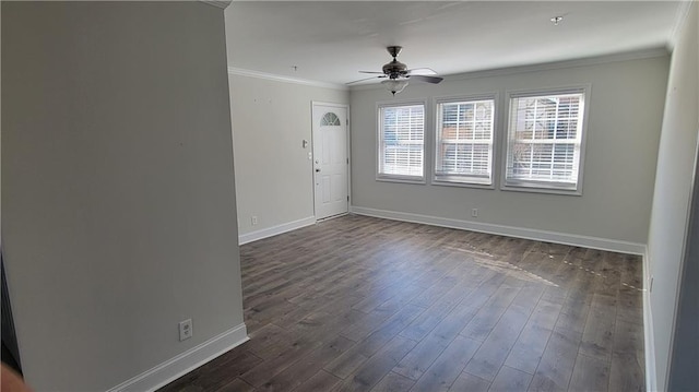 empty room with dark wood-style floors, baseboards, and crown molding