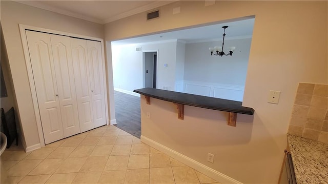 kitchen with visible vents, crown molding, an inviting chandelier, and light tile patterned floors