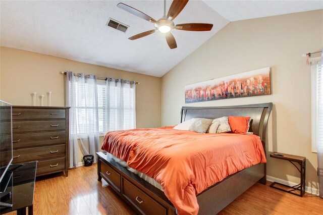 bedroom featuring light hardwood / wood-style flooring, ceiling fan, and vaulted ceiling