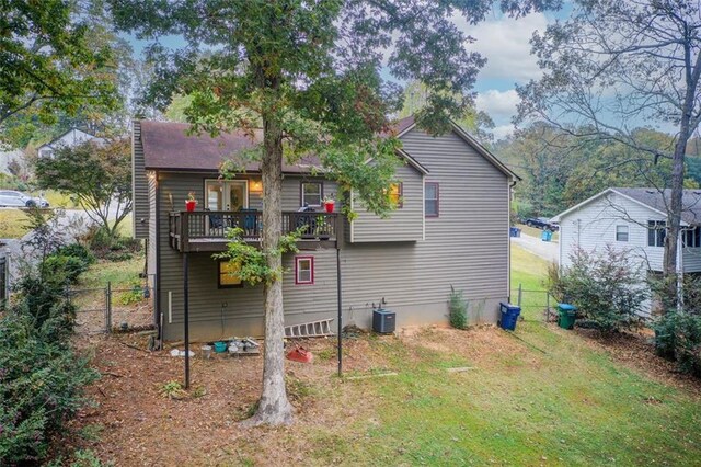 back of house featuring central AC and a yard