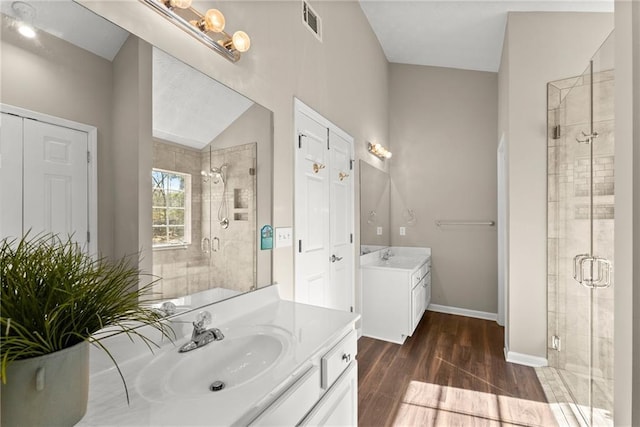 bathroom featuring vanity, hardwood / wood-style flooring, and a shower with shower door