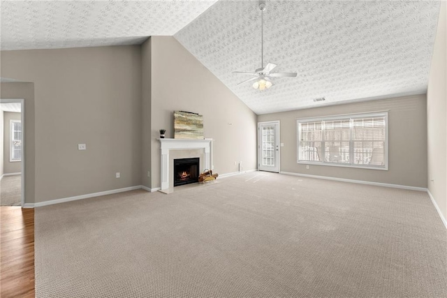 unfurnished living room with a textured ceiling, high vaulted ceiling, light colored carpet, and ceiling fan