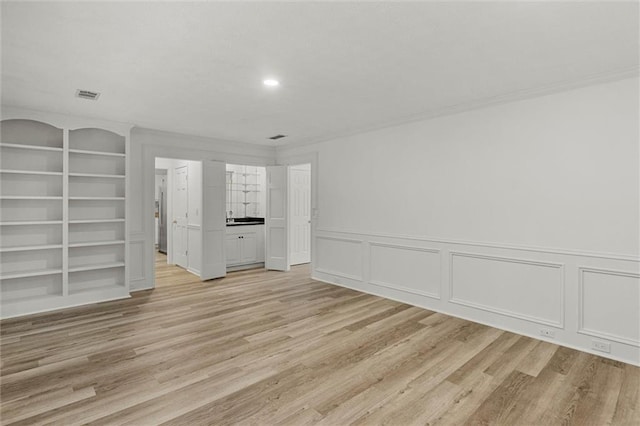 4220 Singing Post Ln NE, Roswell, GA 30075 - spare room featuring light wood-type flooring, built in features, a decorative wall, wainscoting, and recessed lighting
