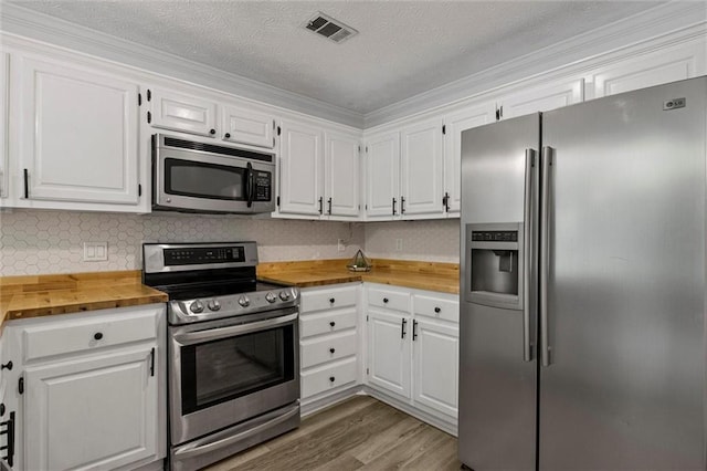 4220 Singing Post Ln NE, Roswell, GA 30075 - kitchen with appliances with stainless steel finishes, butcher block counters, white cabinets, light wood-type flooring, and a textured ceiling