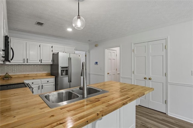 4220 Singing Post Ln NE, Roswell, GA 30075 - kitchen featuring butcher block counters, stainless steel appliances, a sink, wood finished floors, and crown molding