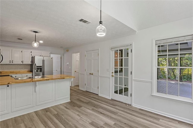 4220 Singing Post Ln NE, Roswell, GA 30075 - kitchen featuring butcher block countertops, stainless steel fridge, a sink, a textured ceiling, and light wood-type flooring