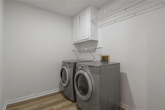 4220 Singing Post Ln NE, Roswell, GA 30075 - laundry room with washer and dryer, cabinet space, baseboards, and light wood-style flooring