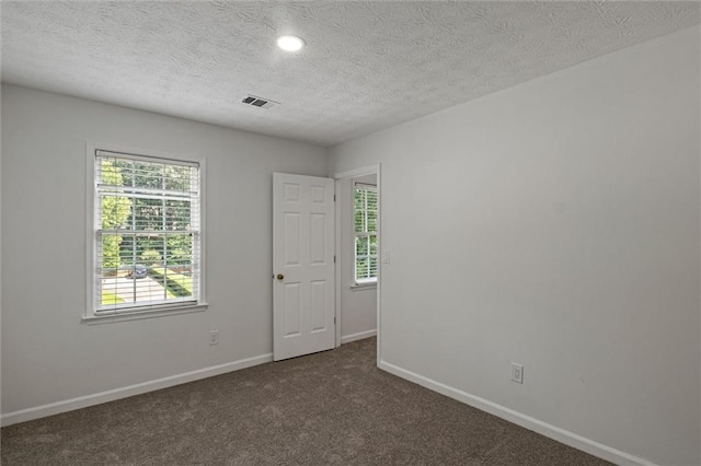 4220 Singing Post Ln NE, Roswell, GA 30075 - empty room with plenty of natural light, baseboards, dark carpet, a textured ceiling, and recessed lighting