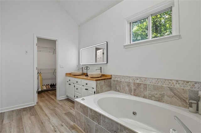 4220 Singing Post Ln NE, Roswell, GA 30075 - full bathroom featuring lofted ceiling, a whirlpool tub, double vanity, wood finished floors, and a spacious closet