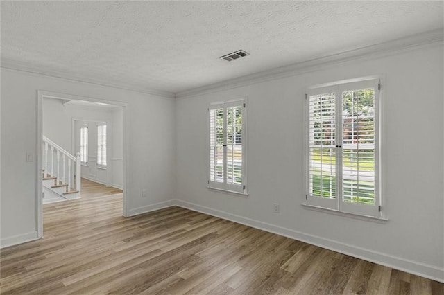 4220 Singing Post Ln NE, Roswell, GA 30075 - empty room with light wood finished floors, ornamental molding, a textured ceiling, baseboards, and stairway