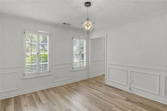 4220 Singing Post Ln NE, Roswell, GA 30075 - unfurnished dining area with plenty of natural light, a decorative wall, crown molding, a textured ceiling, and light wood-type flooring