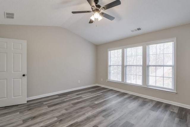 spare room featuring visible vents, vaulted ceiling, and baseboards