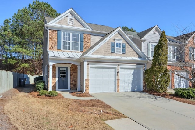 view of front of property featuring a garage, concrete driveway, stone siding, a standing seam roof, and fence