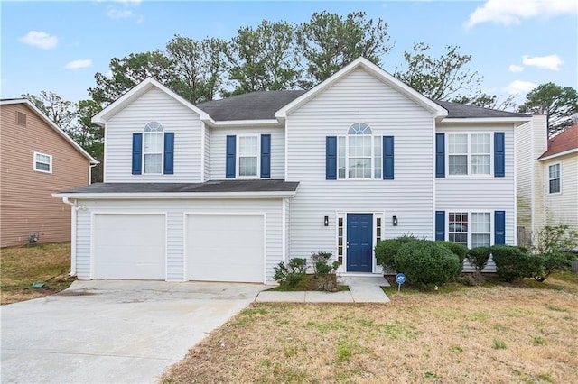 view of front of property featuring a garage, concrete driveway, and a front yard