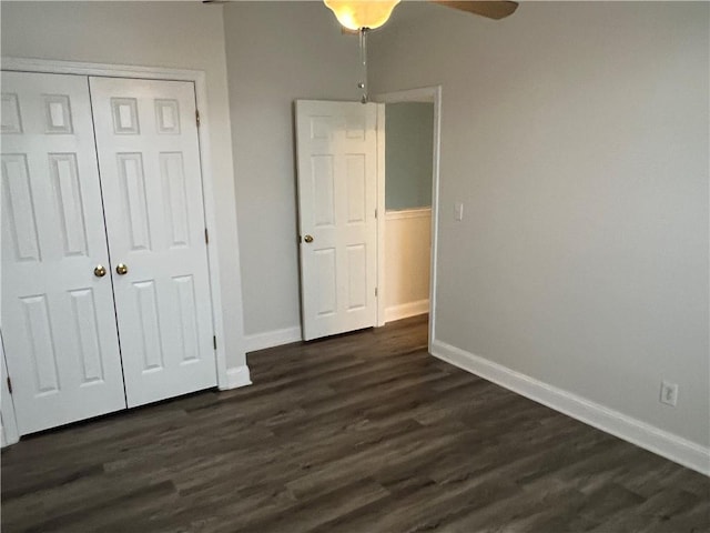 unfurnished bedroom featuring ceiling fan, dark hardwood / wood-style flooring, and a closet