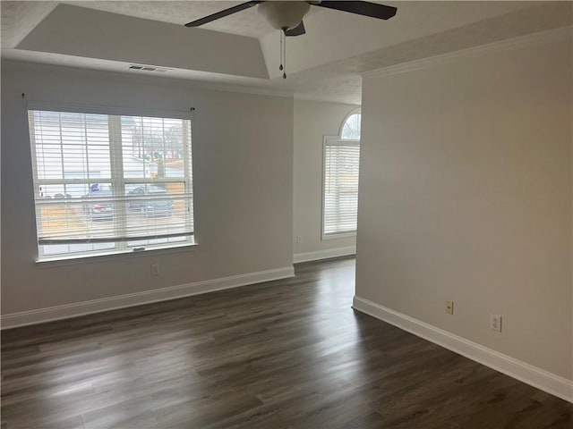 empty room featuring ceiling fan, a tray ceiling, dark hardwood / wood-style flooring, and a textured ceiling