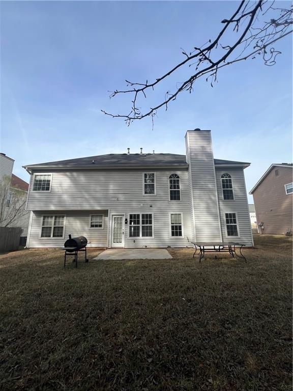 rear view of property with a yard and a patio area