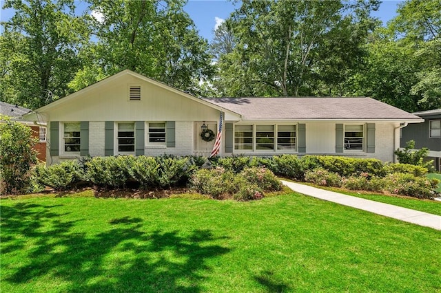 ranch-style home featuring brick siding and a front yard