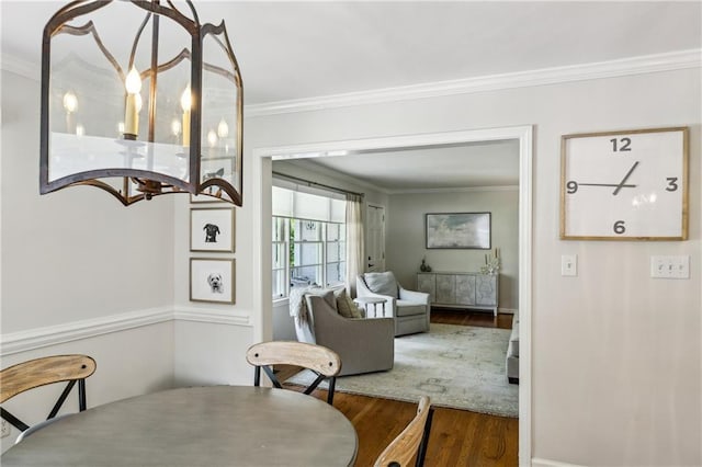 dining area featuring wood finished floors and crown molding