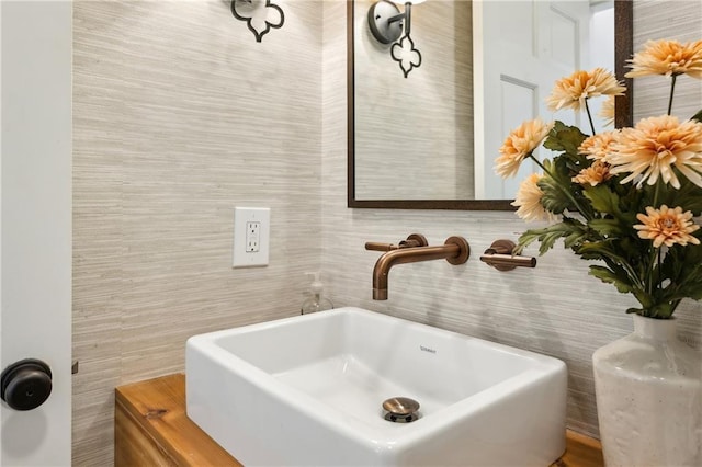 bathroom with a sink and tile walls