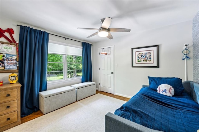 bedroom featuring wood finished floors, a ceiling fan, and baseboards