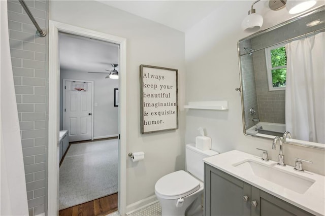 bathroom with baseboards, ceiling fan, toilet, and vanity