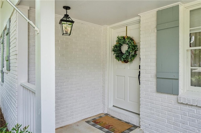 view of exterior entry featuring brick siding