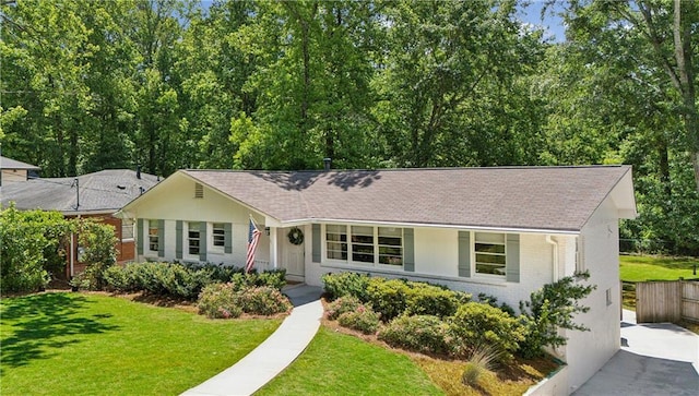 ranch-style home featuring brick siding and roof with shingles