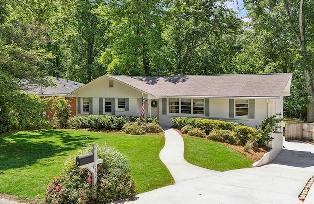 single story home featuring brick siding, a front lawn, and roof with shingles