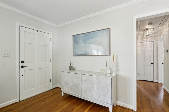 entryway with wood finished floors, crown molding, and baseboards