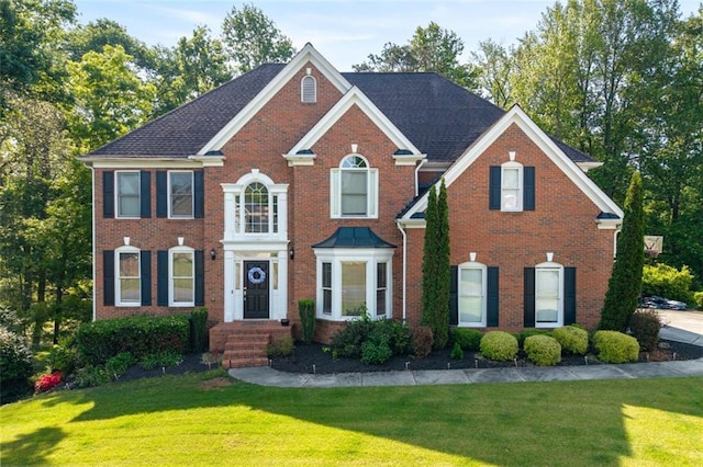colonial-style house with a front yard and brick siding