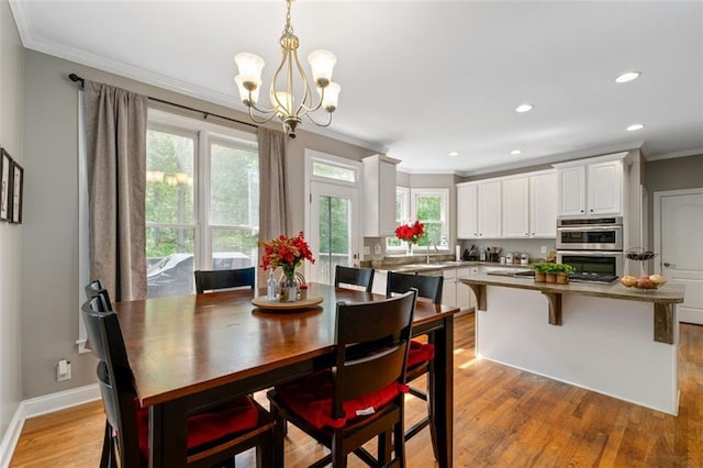 dining space featuring crown molding, a chandelier, light wood-style flooring, recessed lighting, and baseboards