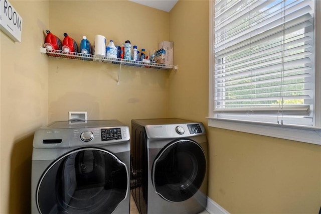 washroom with independent washer and dryer and baseboards