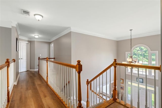 hall featuring an upstairs landing, wood finished floors, a chandelier, crown molding, and baseboards
