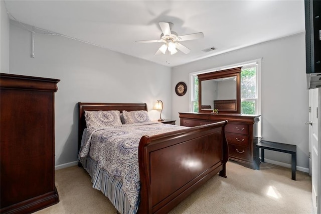 bedroom featuring light colored carpet, baseboards, and ceiling fan
