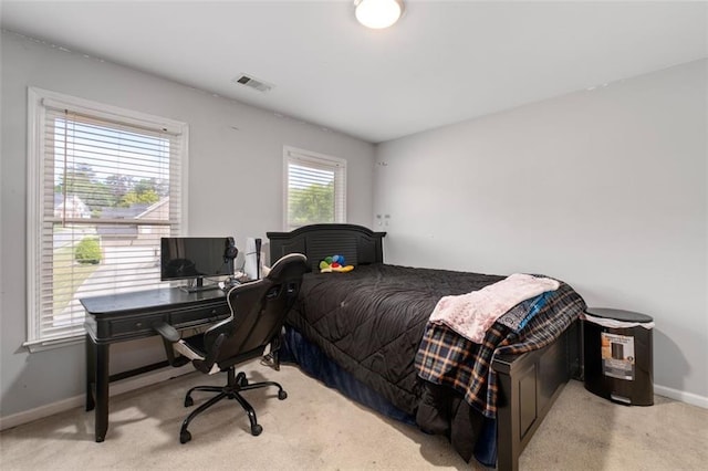 bedroom featuring light carpet, baseboards, and an office area