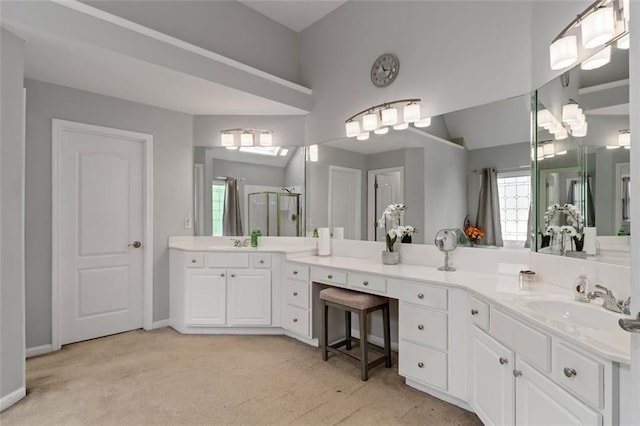full bath featuring a stall shower, baseboards, vanity, and lofted ceiling